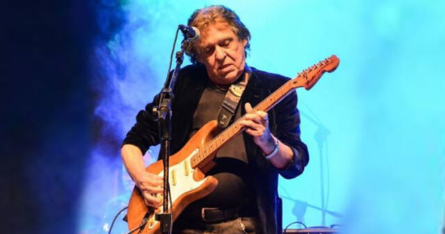 Uma foto que mostra o guitarrista Renato Barros no palco