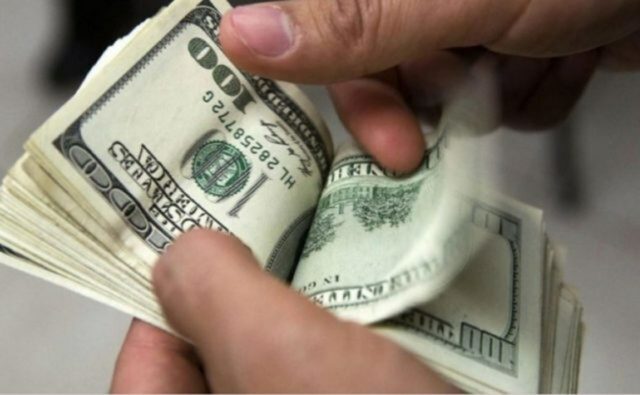 foto de uma mão segurando algumas cédulas de dólar