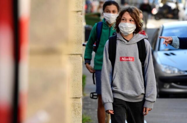 Uma foto dos estudantes indo à escola de máscara Uma foto dos estudantes indo à escola de máscara