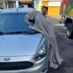 Homem morre e fica em pé, ao lado de carro; populares se assustam