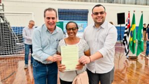 A-cuidadora-Sonia-Maria-Gomes-Domingos-foi-a-primeira-moradora-e-receber-sua-matricula-das-maos-do-prefeito-Helinho-Zanatta-e-do-secretario-Alvaro-Saviani-1024×576