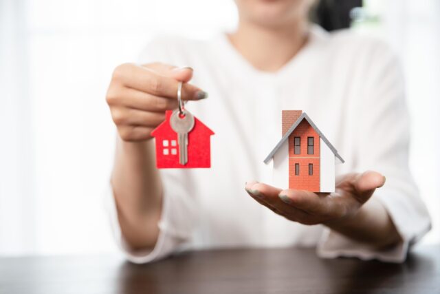 9312245-mulher-segurando-casa-modelo-e-casa-chave-na-mao-gratis-foto